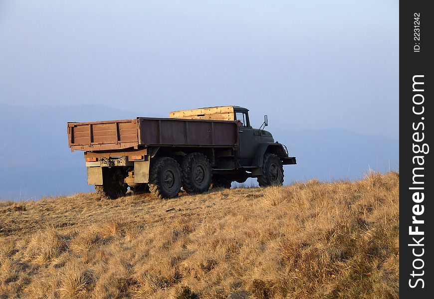 Old truck standing on the hill against the sky. Old truck standing on the hill against the sky