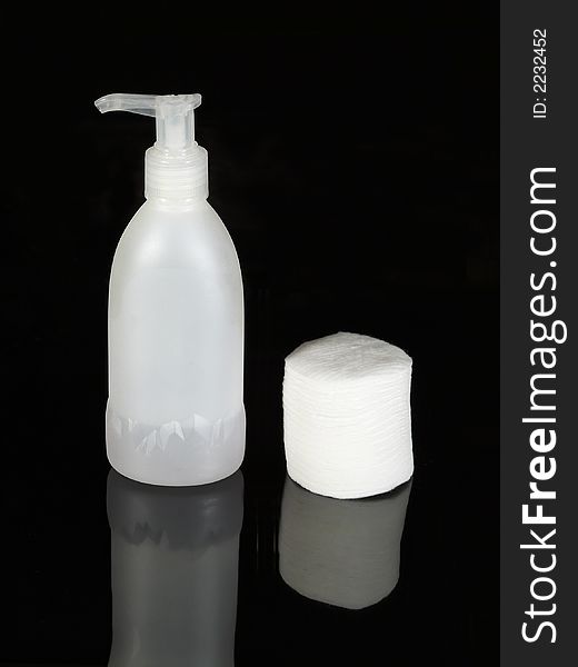 Removal of makeup bottle and cotton slices on black background. Removal of makeup bottle and cotton slices on black background