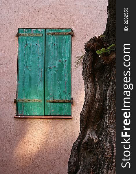 A rustic building with green shutters. A rustic building with green shutters