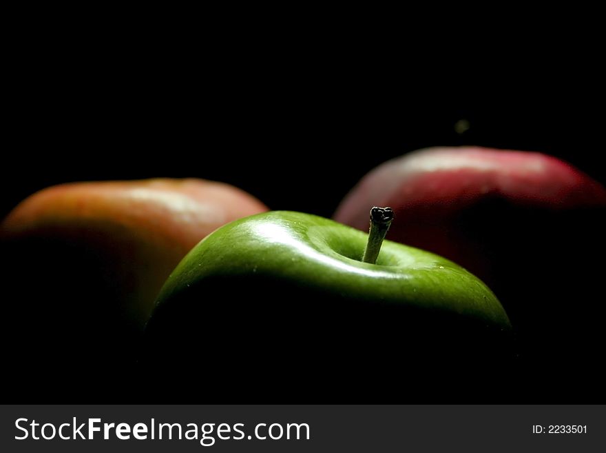 Colourful juicy apples against a black back ground