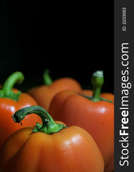 Fresh sweet  orange bell peppers isolated against a black background