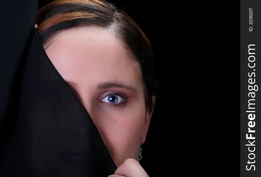 Woman covering half of her face on black background. Woman covering half of her face on black background