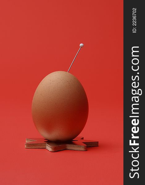 Egg with a needle with red background. Egg with a needle with red background