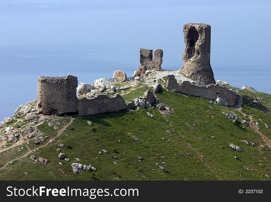 Ruins of an ancient fortress above the blue sea