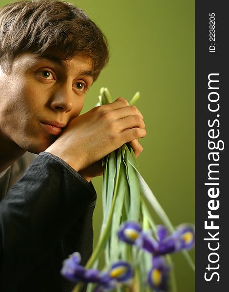 Young the man with a bouquet of irises in hands. Young the man with a bouquet of irises in hands