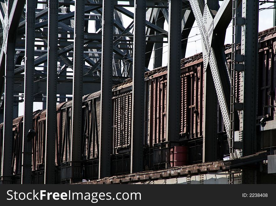 Cargo train crossing old iron bridge