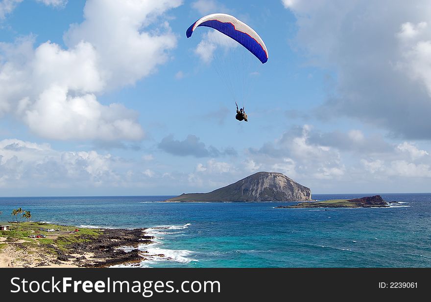 This is a photo of a parachuter over the ocean in Hawaii. This is a photo of a parachuter over the ocean in Hawaii.