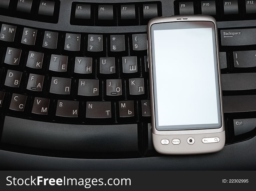 Business concept - closeup image of white touch phone over laptop. Business concept - closeup image of white touch phone over laptop