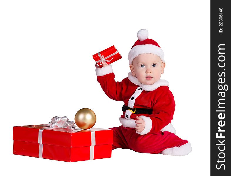 Little baby boy wearing Santa's costume sitting and holding a box with christmas 
presents. Little baby boy wearing Santa's costume sitting and holding a box with christmas 
presents