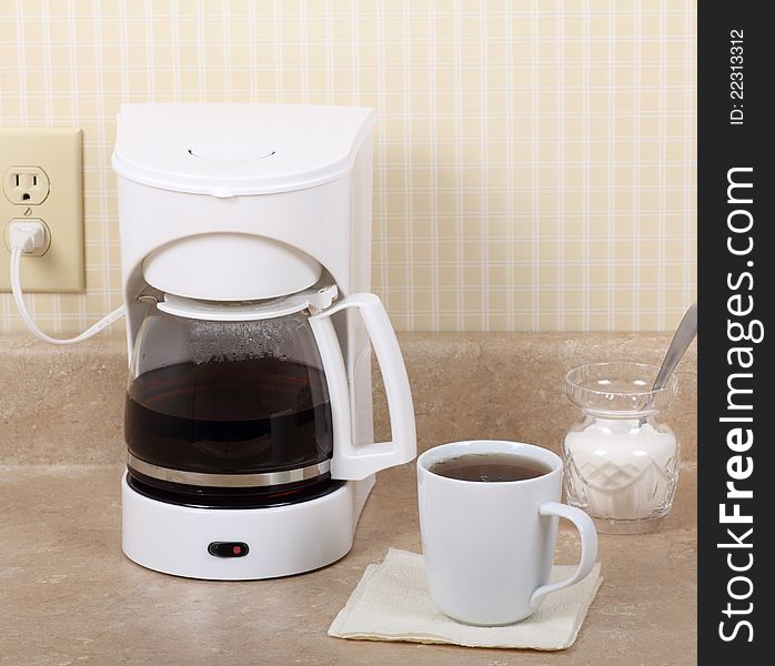 Coffee maker, cup of coffee and sugar bowl on kitchen counter. Coffee maker, cup of coffee and sugar bowl on kitchen counter