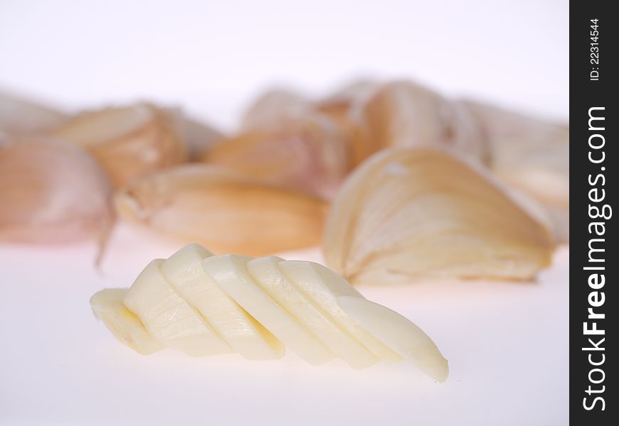 Sliced raw garlic in white background