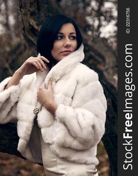 Elegant girl with black hair in white coat with high collar. Elegant girl with black hair in white coat with high collar