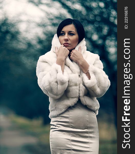 Elegant girl with black hair in white coat with high collar. Elegant girl with black hair in white coat with high collar