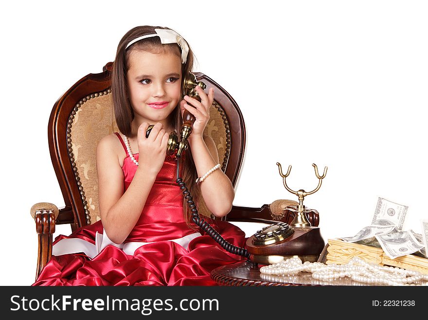 Beautiful little girl in red evening dress speaking on the phone on white background