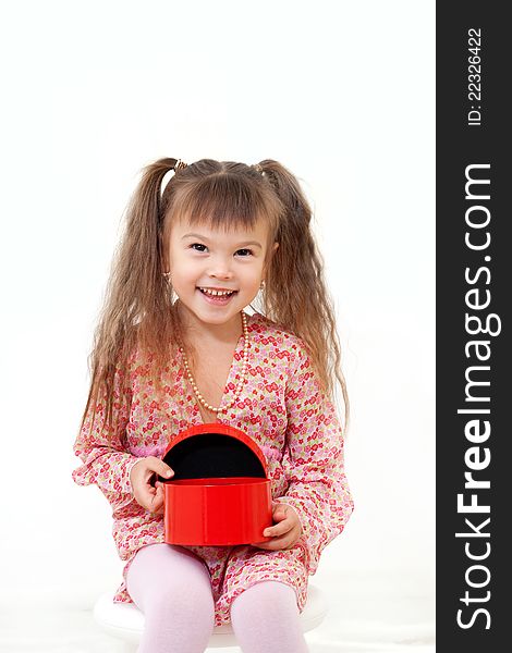 Smiling little girl is happy about her birthday present in red box isolated on white. Smiling little girl is happy about her birthday present in red box isolated on white