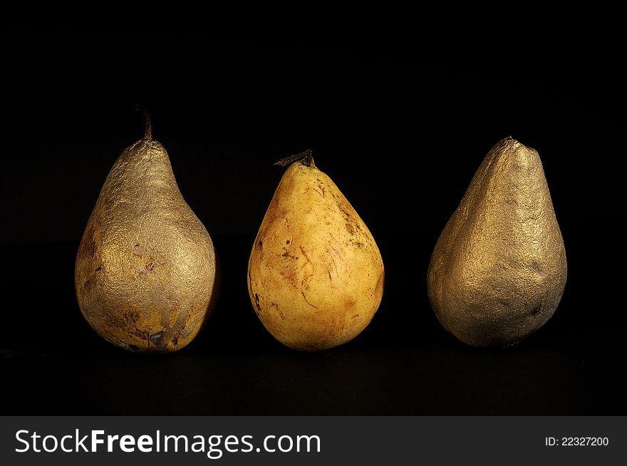 Different golden pears studio isolated on black background for christmas decorations. Different golden pears studio isolated on black background for christmas decorations