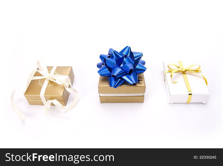 Set of three gold and white gift boxes with blue ribbon. Set of three gold and white gift boxes with blue ribbon.