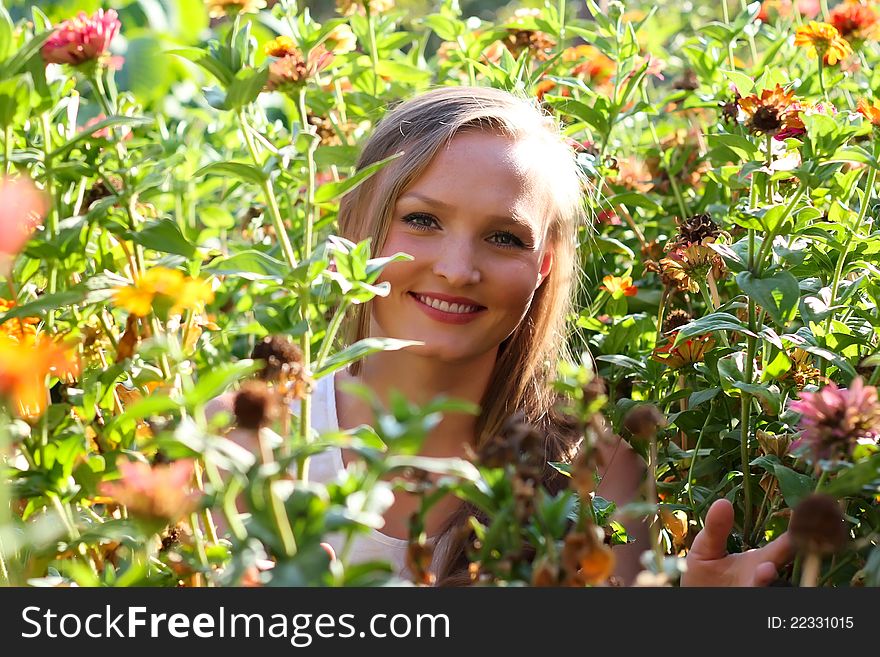 Beautiful young woman among the flowers