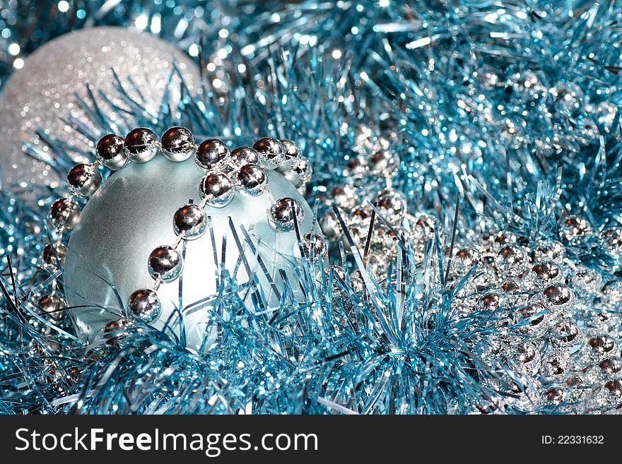 Christmas style decorations arrangement of two sparkling balls silver chain beads and blue tinsel. Christmas style decorations arrangement of two sparkling balls silver chain beads and blue tinsel