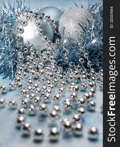 Festive decorations arrangement of three sparkling balls silver chain beads and blue tinsel. Festive decorations arrangement of three sparkling balls silver chain beads and blue tinsel