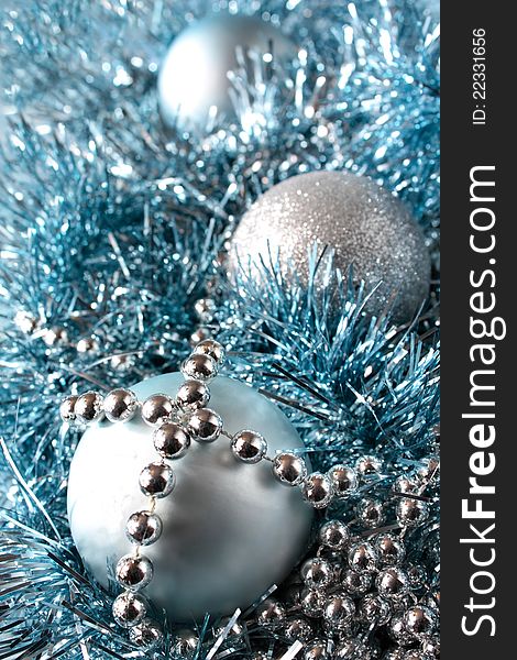 Festive decorations arrangement of three sparkling balls silver chain beads and blue tinsel. Festive decorations arrangement of three sparkling balls silver chain beads and blue tinsel