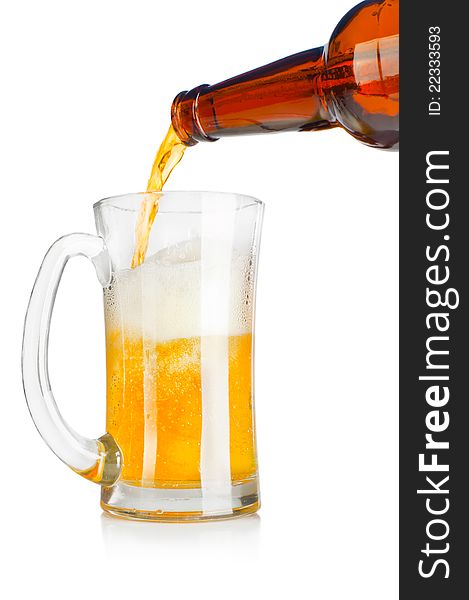 Beer pouring from glass bottle into a mug over white background. Beer pouring from glass bottle into a mug over white background