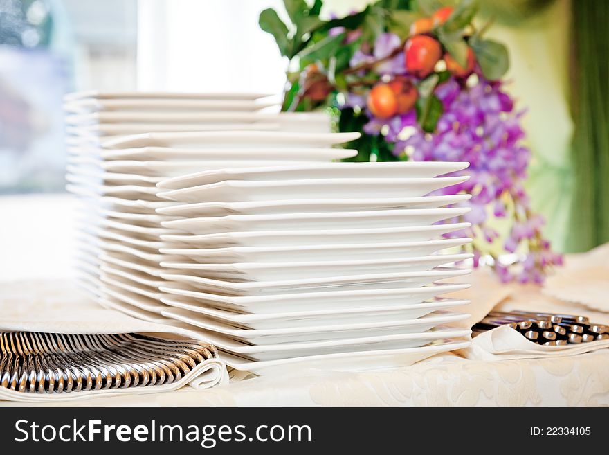 Stacks of white plates for a buffet.