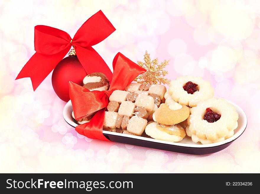 Luxurious festive christmas biscuits with red christmas ball and ribbon. Festive snack background. Luxurious festive christmas biscuits with red christmas ball and ribbon. Festive snack background.