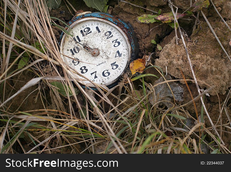 An old antique broken clock lying on the ground. An old antique broken clock lying on the ground