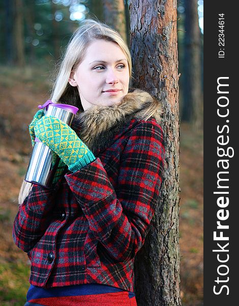 Woman drinking tea from a thermos cup