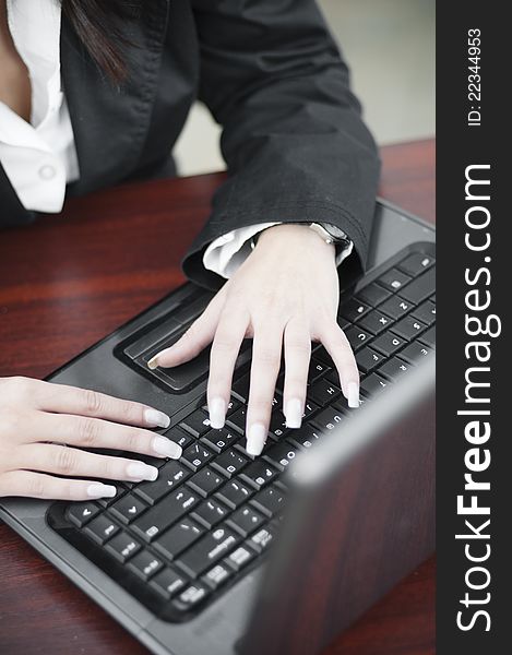 Hands of a business woman dressed in a fancy suit with beautiful hands writing on laptop. Hands of a business woman dressed in a fancy suit with beautiful hands writing on laptop