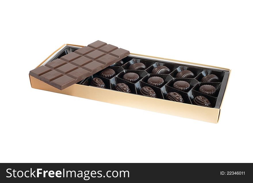 Bar of chocolate on box with candies on white background. Isolated with clipping path. Bar of chocolate on box with candies on white background. Isolated with clipping path