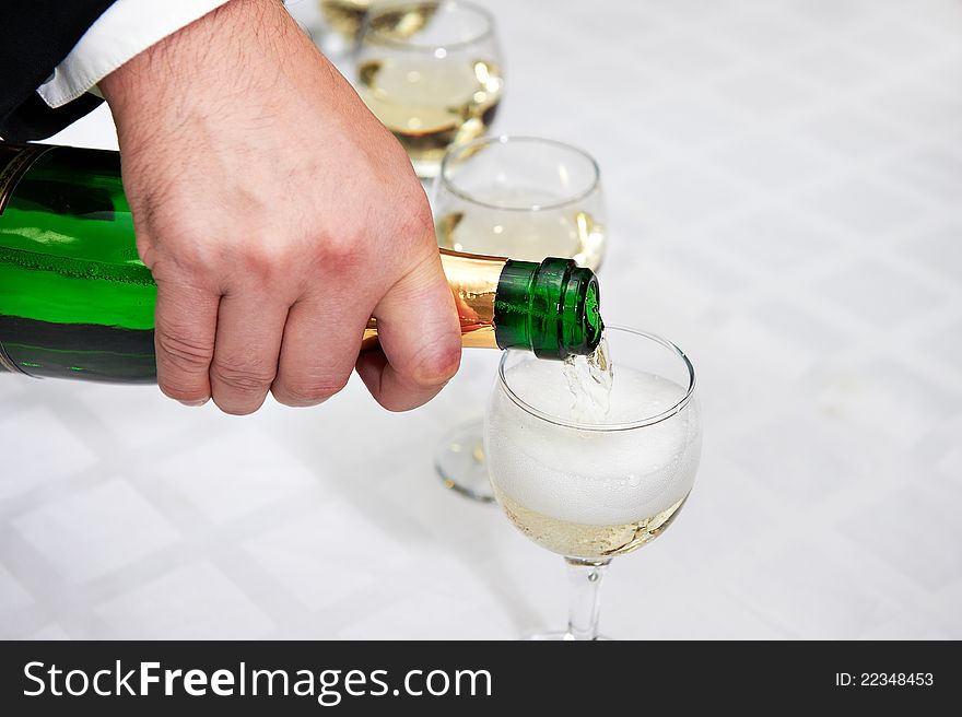 Pouring of champagne glasses on white table