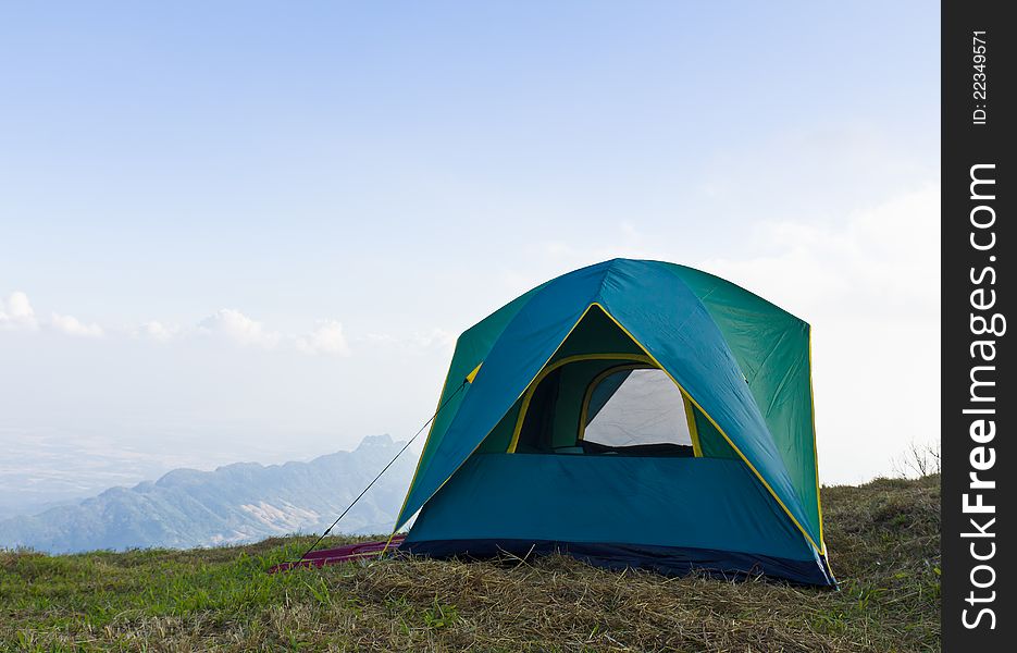 Tent on a grass under white clouds and blue sky