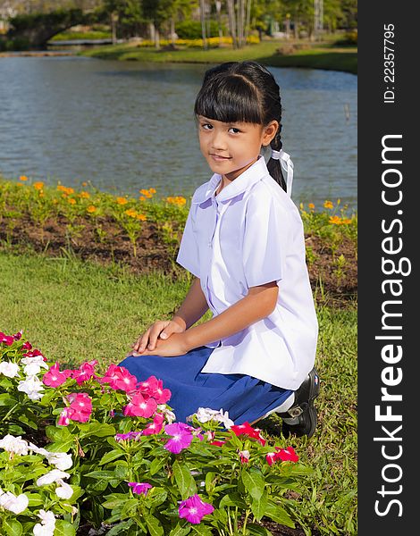 Little asian girl in student uniform smile on flowers background. Little asian girl in student uniform smile on flowers background