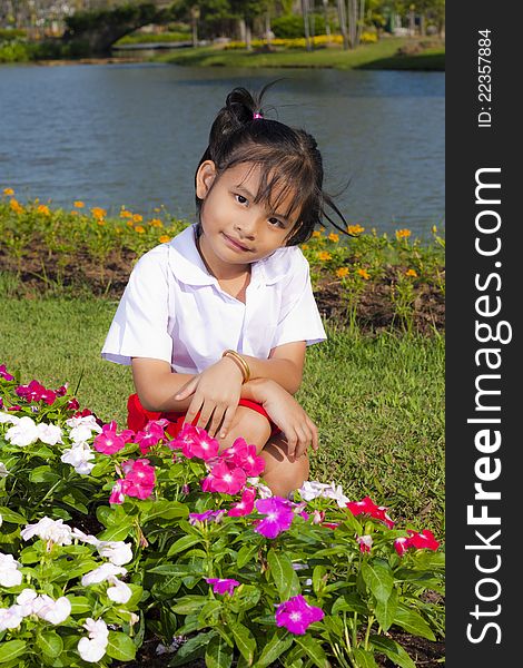 Little asian girl in student uniform smile on flowers background. Little asian girl in student uniform smile on flowers background