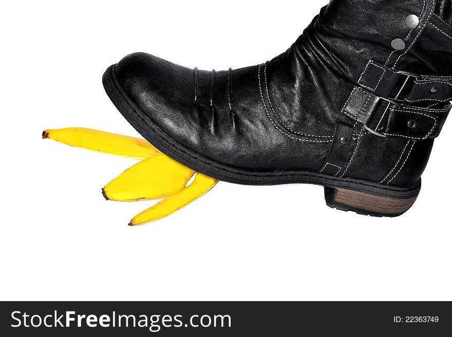 Black boot stepping on a banana peel. Black boot stepping on a banana peel