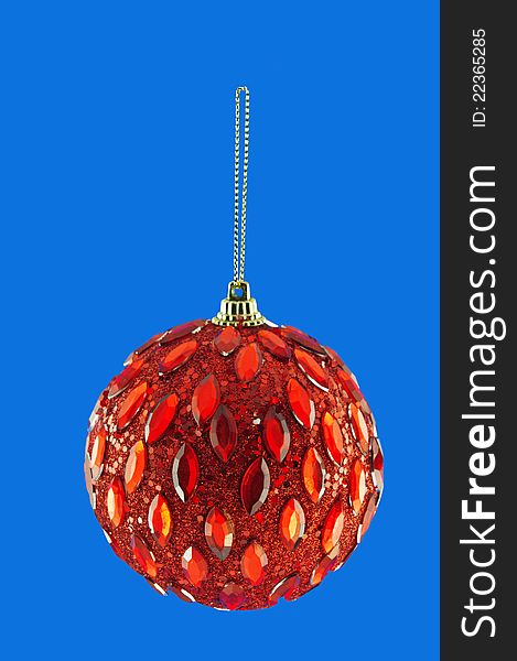 Red ball, Christmas decorations hanging on a golden thread against the blue background