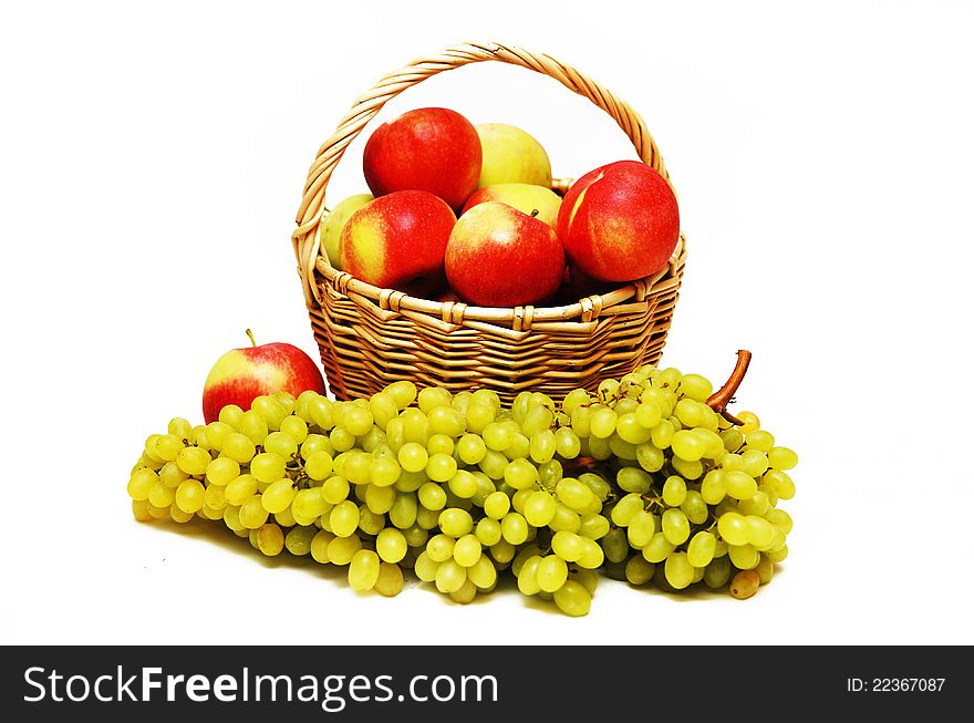 Apples in a basket and grapes in the foreground