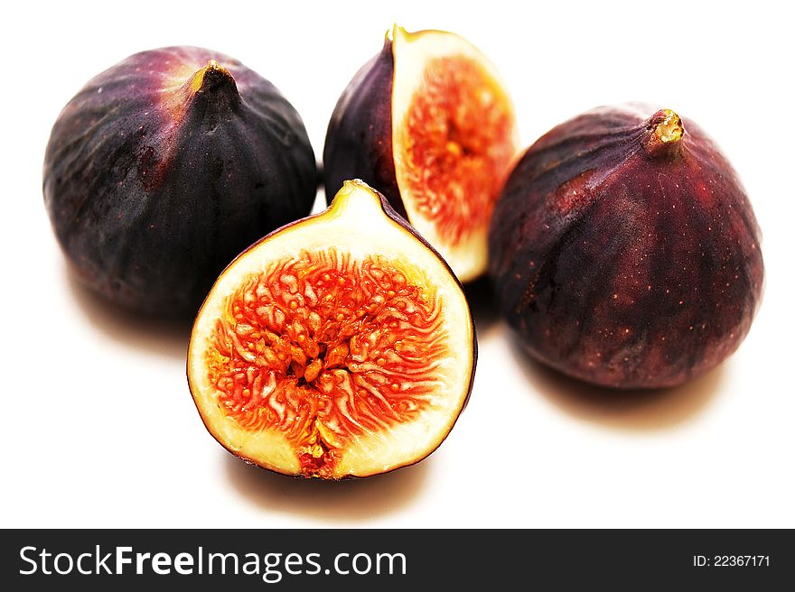 Three figs, one is cut, ripe pulp