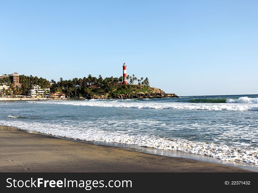 Kovalam international beach on the backdrop of hotels, restaurants and lighthouse