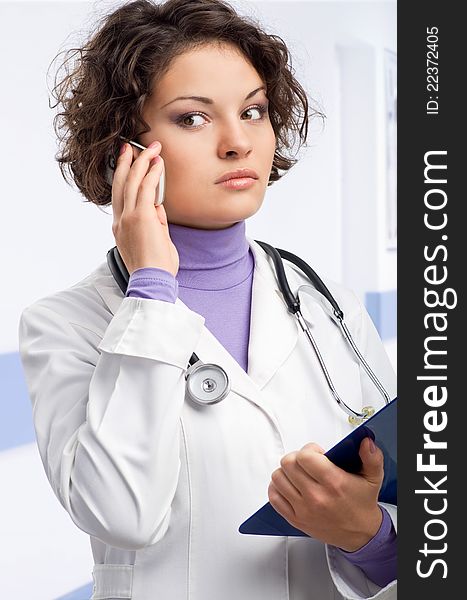 Young doctor in medical gown and a stethoscope and file folder in an hospital. Young doctor in medical gown and a stethoscope and file folder in an hospital