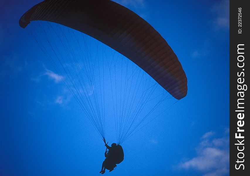 Silhouette of paraglider with two person against the blue sky. Silhouette of paraglider with two person against the blue sky.