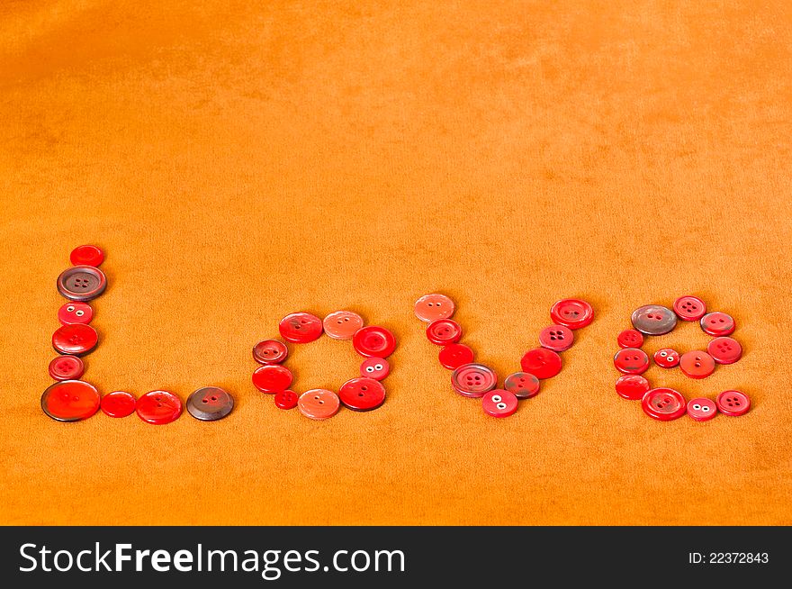 Love text written with red buttons on textured brown background. Love text written with red buttons on textured brown background