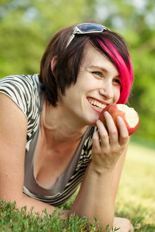 Young Punk Woman Eating An Apple Stock Photography