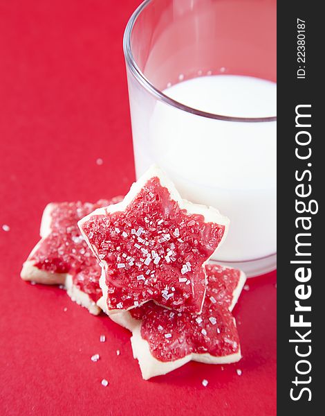 Christmas cookies with glass of milk on red background. Christmas cookies with glass of milk on red background