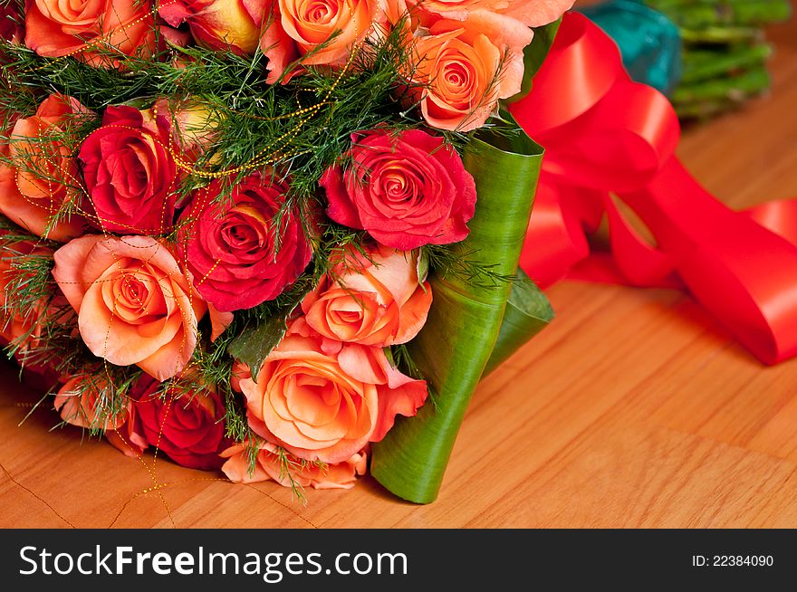 A beautiful bright coloured bouquet with fresh roses and a red ribbon. A beautiful bright coloured bouquet with fresh roses and a red ribbon