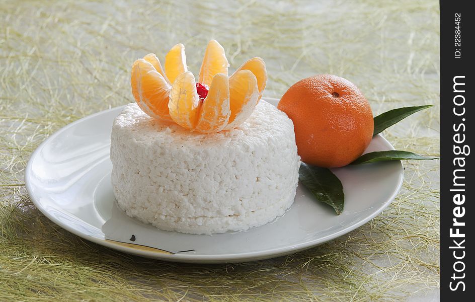 Dairy breakfast, cottage cheese on a plate, and segments of the cleared tangerine