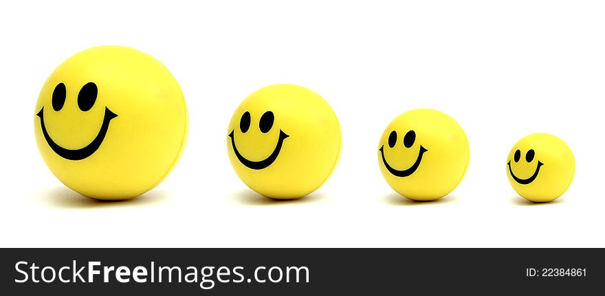 Four smiling yellow balls waiting in line over a white background