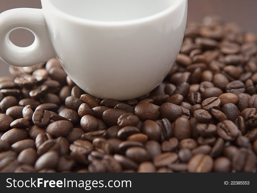 White cup on the coffee beans background